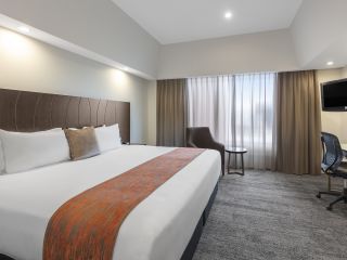 A Bedroom With A Large Bed In A Hotel Room